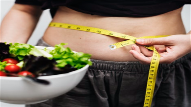 Woman measuring waist with tape measure