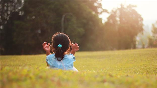 Girl in field with sun shining