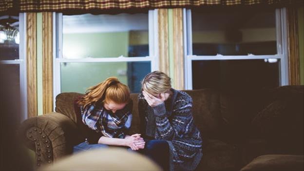 man and woman sitting on sofa in a room