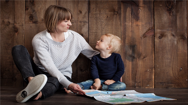 Mother sitting beside son with wooden background